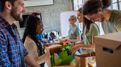 Group of volunteers with working in community charity donation center.