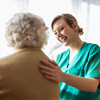 Friendly nurse supporting an elderly lady